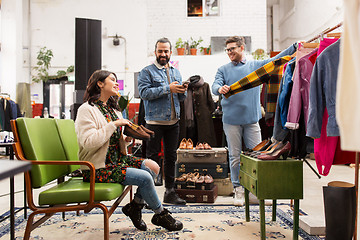 Image showing friends choosing clothes at vintage clothing store