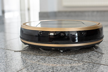 Image showing Robotic vacuum cleaner on bright marble floor