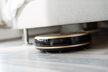 Image showing Robot vacuum cleaner runs under bed