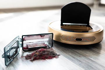 Image showing robotic vacuum cleaner on wood floor with emptied dirt container