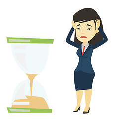 Image showing Desperate business woman looking at hourglass.