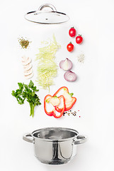 Image showing Assorted fresh vegetables falling into a bowl, on white background