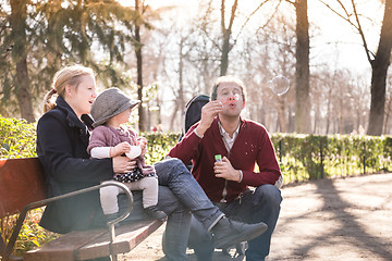 Image showing Young family with cheerful child in the park.