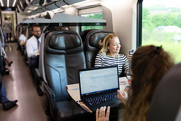 Image showing Businesswoman communicating on mobile phone while traveling by train.