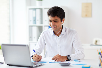 Image showing businessman in earphones working at office