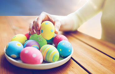 Image showing close up of woman hands with colored easter eggs