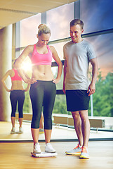 Image showing smiling man and woman with scales in gym