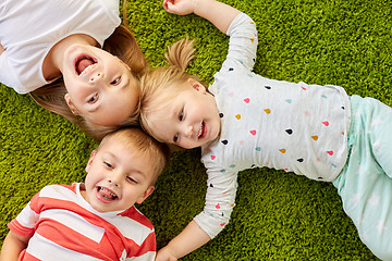 Image showing happy little kids lying on floor or carpet