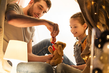 Image showing happy family playing with toy in kids tent at home