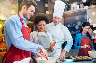 Image showing happy friends and chef cook baking in kitchen