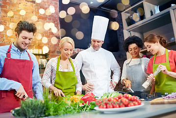 Image showing happy friends and chef cook cooking in kitchen