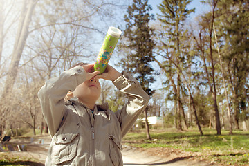 Image showing Boy looking at the kaleidoscope outdoors