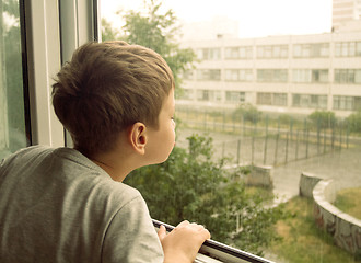 Image showing Boy watching the rain through the window