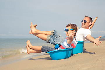 Image showing Father and son  playing on the beach at the day time.