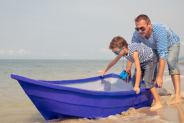 Image showing Father and son  playing on the beach at the day time.