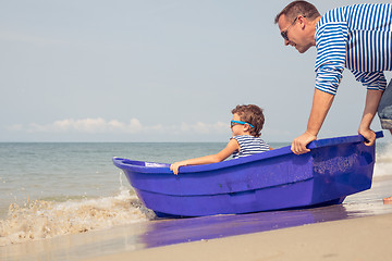 Image showing Father and son  playing on the beach at the day time.