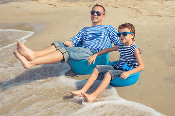 Image showing Father and son  playing on the beach at the day time.