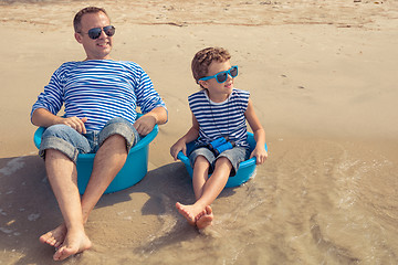 Image showing Father and son  playing on the beach at the day time.