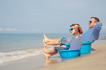 Image showing Father and son  playing on the beach at the day time.