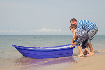 Image showing Father and son  playing on the beach at the day time.