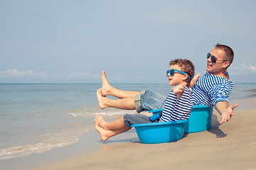 Image showing Father and son  playing on the beach at the day time.