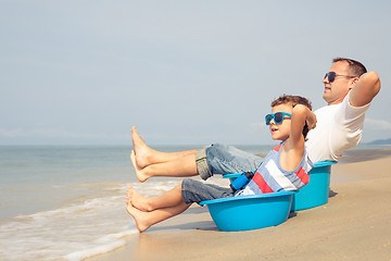 Image showing Father and son  playing on the beach at the day time.