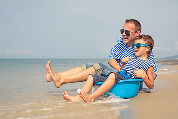 Image showing Father and son  playing on the beach at the day time.