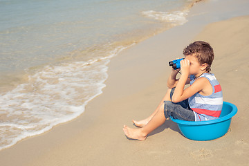 Image showing One happy little boy playing on the beach at the day time.