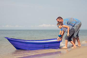 Image showing Father and son  playing on the beach at the day time.