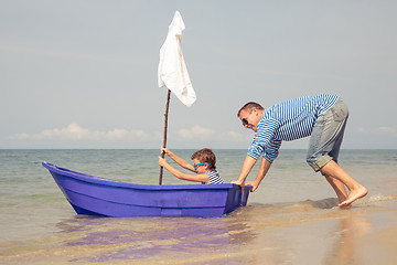 Image showing Father and son  playing on the beach at the day time.