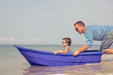 Image showing Father and son  playing on the beach at the day time.