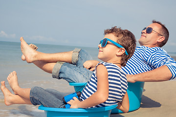 Image showing Father and son  playing on the beach at the day time.