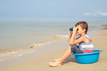 Image showing One happy little boy playing on the beach at the day time.