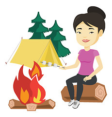 Image showing Woman roasting marshmallow over campfire.