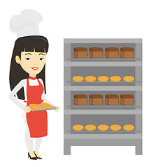 Image showing Happy young female baker holding tray of bread.