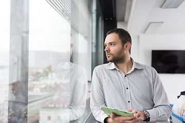 Image showing Businessman Using Tablet In Office Building by window