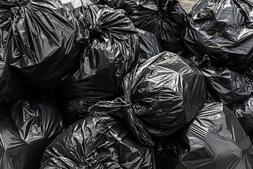 Image showing Pile of black waste plastic bin bag background.