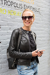 Image showing Woman using smartphone against colorful graffiti wall in New York city, USA.