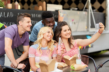 Image showing happy young friends taking selfie at food truck