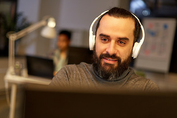 Image showing creative man with headphones working at office