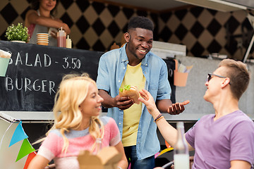 Image showing happy friends with drinks eating at food truck