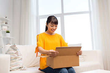 Image showing happy asian young woman with parcel box at home