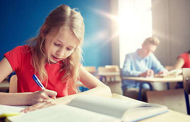 Image showing student girl with book writing school test