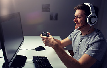 Image showing man in headset playing computer video game at home