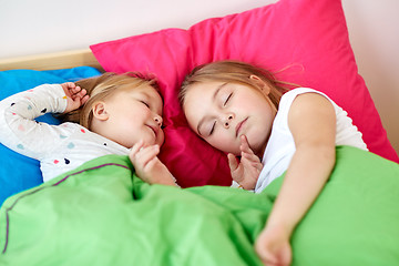 Image showing happy little girls sleeping in bed at home