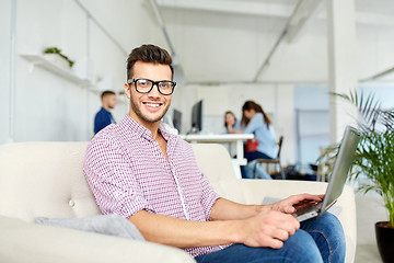 Image showing man in eyeglasses with laptop working at office