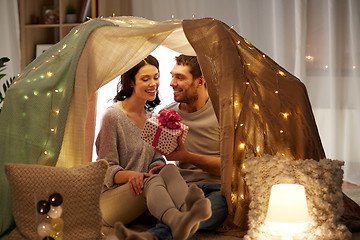 Image showing happy couple with gift box in kids tent at home