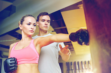Image showing woman with personal trainer boxing in gym