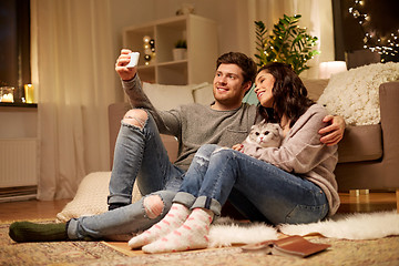 Image showing happy couple taking selfie by smartphone at home