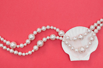 Image showing Pearl necklace and seashell on pink background